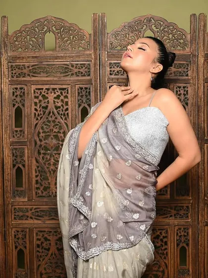 A more expressive, artistic pose that conveys emotion. The lighting highlights the model's features and the texture of the saree, creating a moody and captivating portrait.