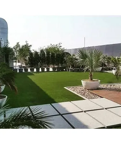 This terrace garden combines a lush artificial lawn with large potted plants and a wooden deck. It's a perfect low-maintenance solution for creating a beautiful and usable rooftop space.
