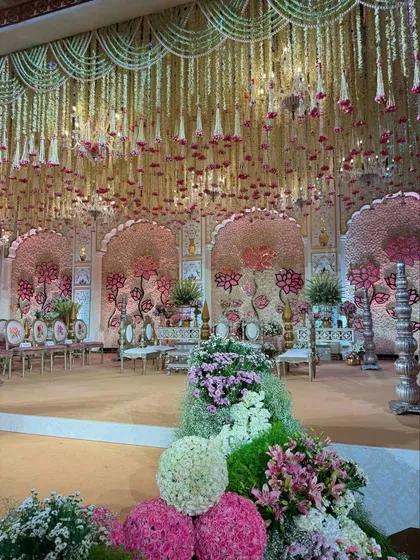 A symphony of blooms, brass, and carved elegance. This wide shot captures the grandeur of the entire stage, from the floral-lined aisle to the magnificent backdrop. 🌸