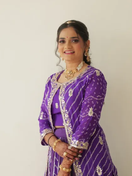 A portrait of the bride in her purple bandhani lehenga. The soft makeup and simple jewelry let the colorful outfit be the star of the show.