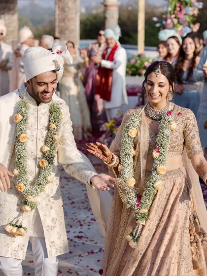 That "just married" walk down the aisle. This candid shot captures the pure joy and relief after the wedding ceremony, with guests cheering them on through a path of beautiful flowers I designed for their special day.