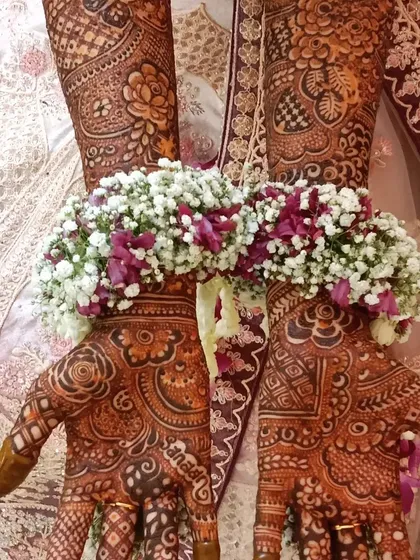 A beautiful shot of traditional mehendi paired with floral jewelry. This captures the complete and authentic wedding day look.