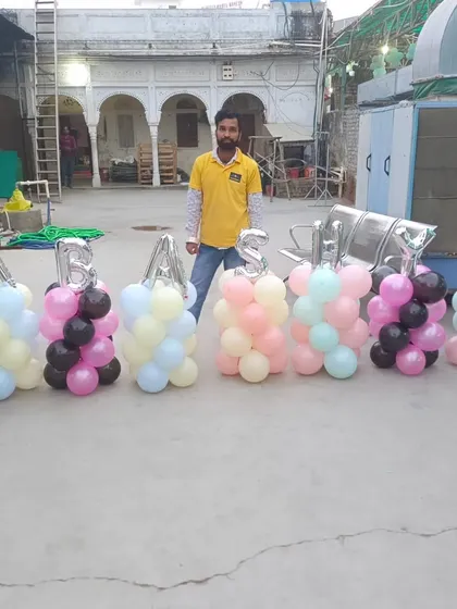 Here I am with the balloon pillars we created for a Khatu Shyam Ji event. We can create any name or message with these balloon letters.