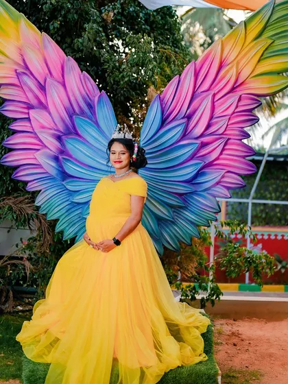 A touch of fantasy for a magical time. These colorful angel wings and the beautiful yellow gown make for a truly unforgettable and vibrant maternity portrait.