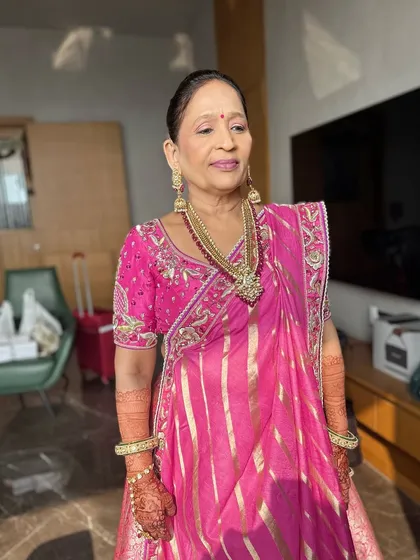A candid moment capturing the mother of the bride's serene elegance. The makeup is soft and natural, allowing her own beauty and grace to shine through.