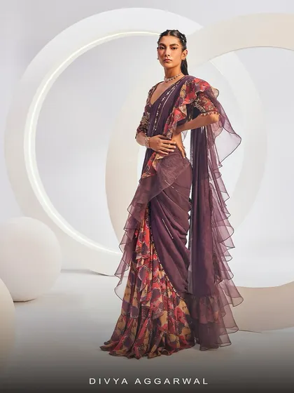 The Delilah Saree Set showcases luscious hues and eclectic prints. This look features a sweetheart neck printed blouse and a printed ruffle saree with embellishments, making it an ethereal fit for festivities.