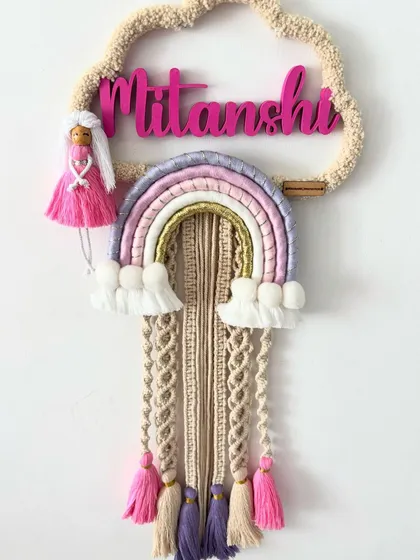 The full 'Mitanshi' name hanging, a beautiful custom piece featuring a doll, a pastel rainbow, and colorful tassels.