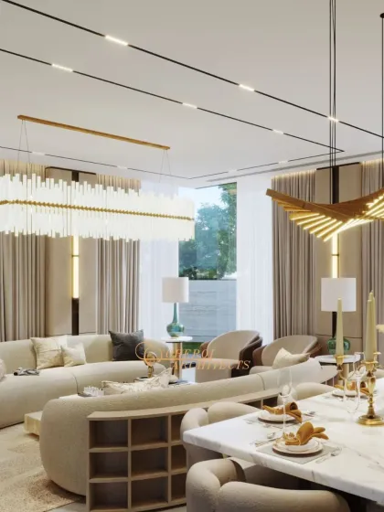 Another view of the open-plan space, highlighting the grand scale of the lighting fixtures and the seamless connection to the outdoor garden area through floor-to-ceiling windows.