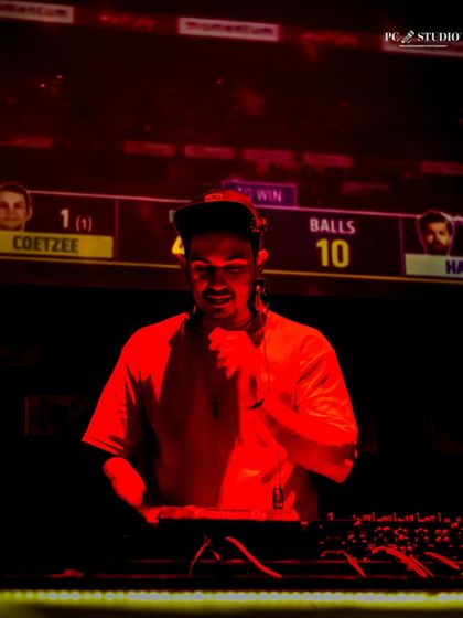 A dramatic, red lit shot of me at the console during a live cricket screening. Even during the match, the party vibe continues.