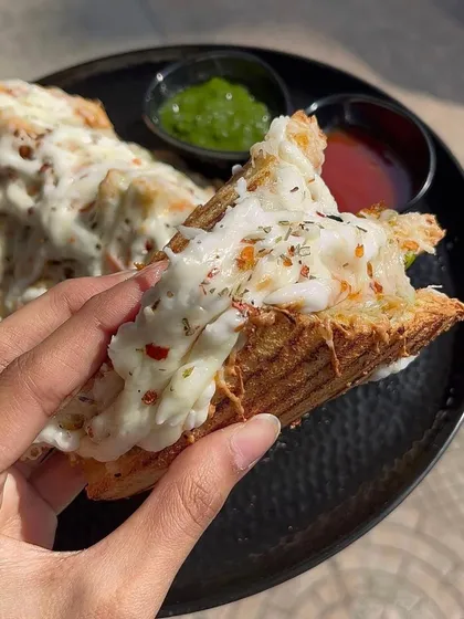 A bite of my cheesy grilled sandwich, showing the delicious filling and melted cheese.