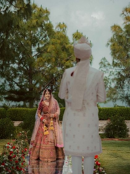 The first look. I capture the groom's back to the camera to build anticipation, focusing entirely on the bride's radiant smile as she sees him for the first time on the wedding day.