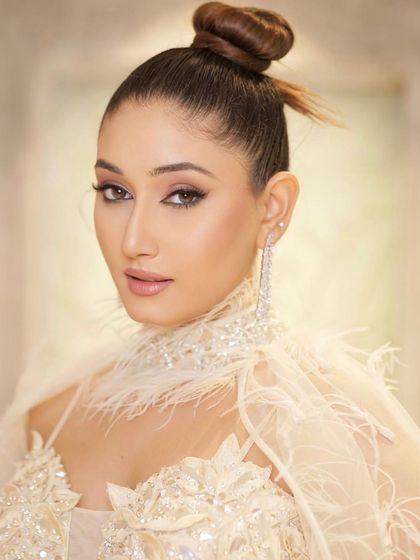 A sleek and chic knotted bun. This is a modern twist on a classic updo, perfect for a sophisticated cocktail or reception look.