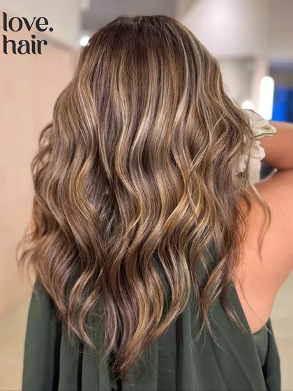 This is that perfect, Pinterest-worthy "bronde" balayage. We used a bleach and tone method to weave buttery, bright highlights into a natural brown base, creating a sun-kissed look with tons of dimension and movement.