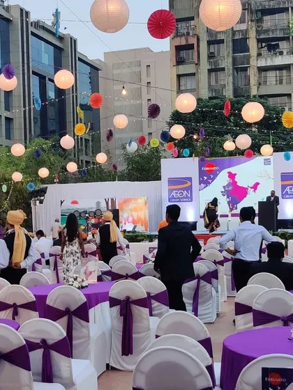 This shows my capability in handling large, themed daytime events. For this AON corporate function, I used a vibrant color palette with purple and white seating, complemented by colorful hanging lanterns to create a festive and engaging atmosphere.