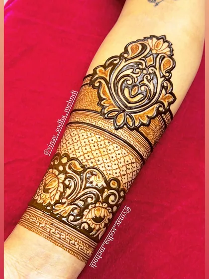A practice cuff design on an arm, featuring a bold paisley and floral pattern.