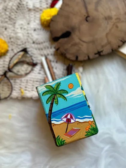 The summer side of the pen stand, with a sunny beach scene.