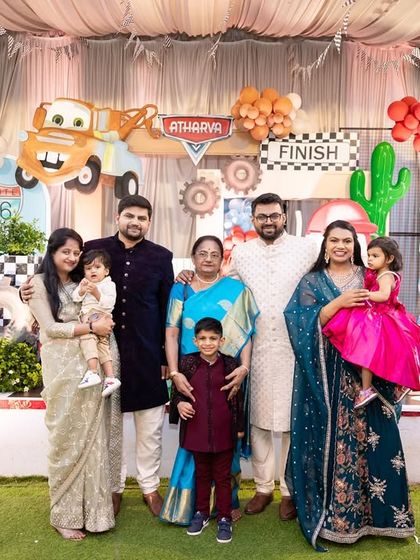 A large family photo at Atharva's Disney Cars party, capturing the joy of the celebration with multiple generations.