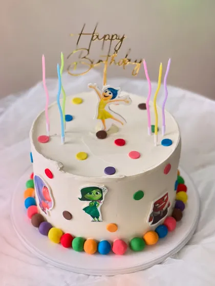 An "Inside Out" themed birthday cake made with my Belgian Chocolate flavor. It's decorated with colorful polka dots, character cutouts, and rainbow candles.