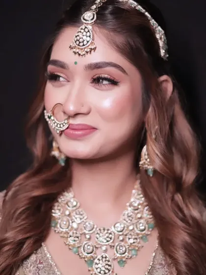 A portrait showing a heavy kundan and mint green stone jewellery set. This is a popular rental for pairing with pastel lehengas.