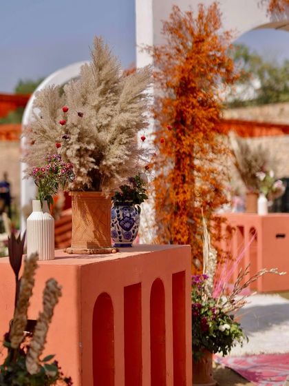 A detail shot of the decor, featuring pampas grass and other dried elements in terracotta and ceramic vases, contributing to the rustic-modern theme.