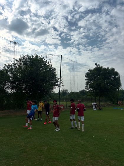 A wide view of a training session under a cloudy sky. No matter the weather, our players show up to work.