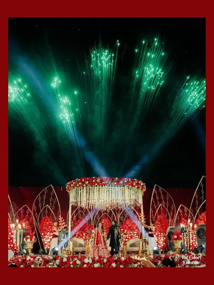 A grand finale for a beautiful wedding. This reception stage featured a stunning floral mandap and a spectacular fireworks display, ending the celebrations on a truly high note.