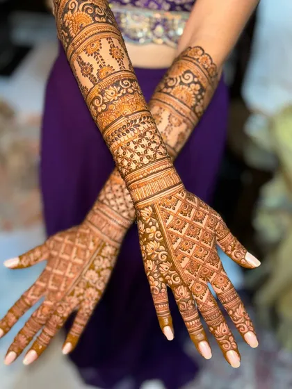 A beautiful back-of-hand design with a mix of grid patterns and floral motifs. The design is intricate and elegant, perfect for a bride or for any festive occasion.