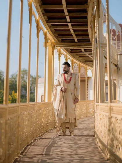 A full-length shot of the groom on a walkway at Lohagarh Fort. The architecture and natural light create a perfect frame for this regal portrait.