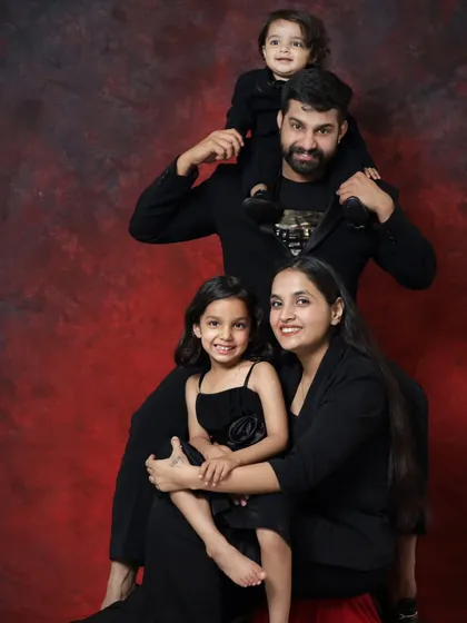 A classic family portrait with a creative pose. The father with his son on his shoulders, and the mother with her daughter, creates a beautiful, balanced, and loving image.