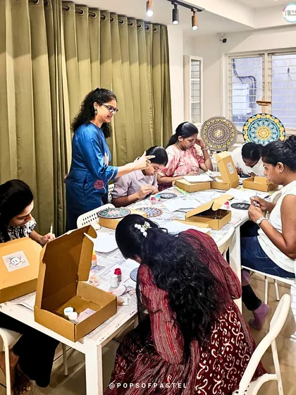 An instructor gives guidance during a dot mandala workshop. We ensure everyone gets the help they need to create something they're proud of.