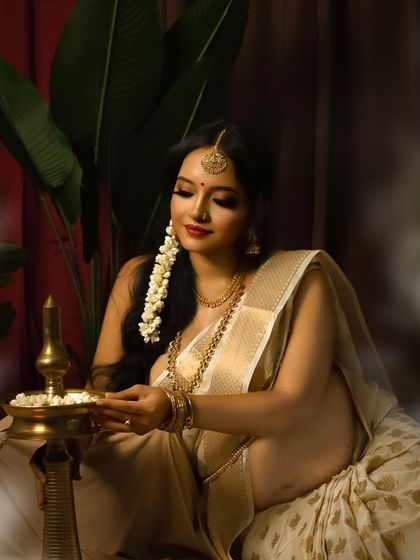 A divine light. This portrait captures the mother-to-be lighting a traditional brass lamp, symbolizing the welcoming of light and life. The classic South Indian styling is elegant and timeless.