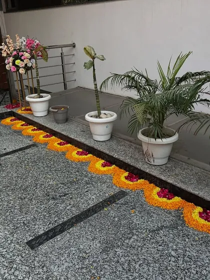 A simple and elegant walkway border made from flower petals, leading to the main event area at a home function.