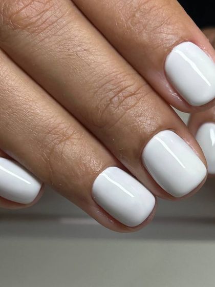 A crisp, opaque white manicure on short, square nails. A fresh and modern choice that is always in style.
