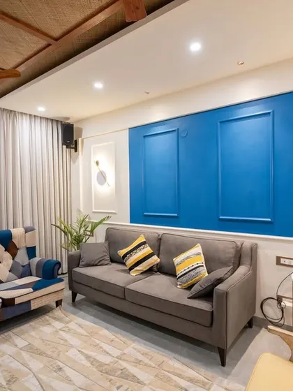 Another angle of the modern living room, focusing on the blue accent wall and the patterned sofa.
