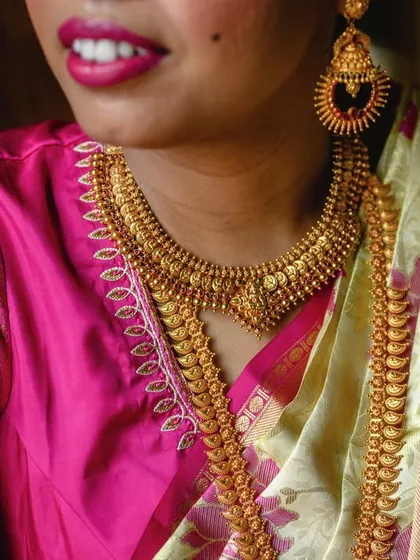 A detailed shot of the bride Amrutha's traditional South Indian gold jewelry. The craftsmanship is exquisite and an important part of her bridal attire.