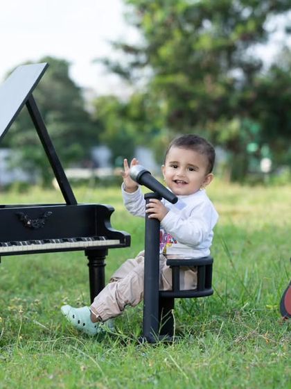 This little rockstar is ready for his outdoor gig, with his piano, guitar, and microphone.