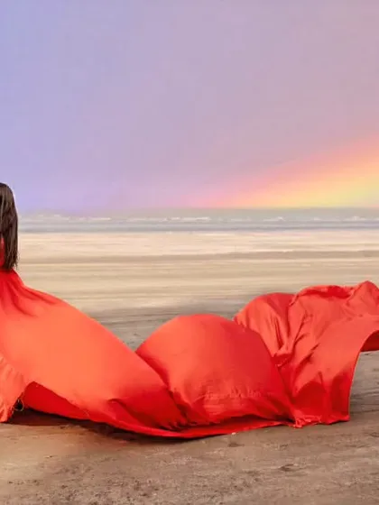 A magical beach scene with a rainbow in the sky. Our classic red trail gown adds to the romance, creating a truly unforgettable pre-wedding photograph.