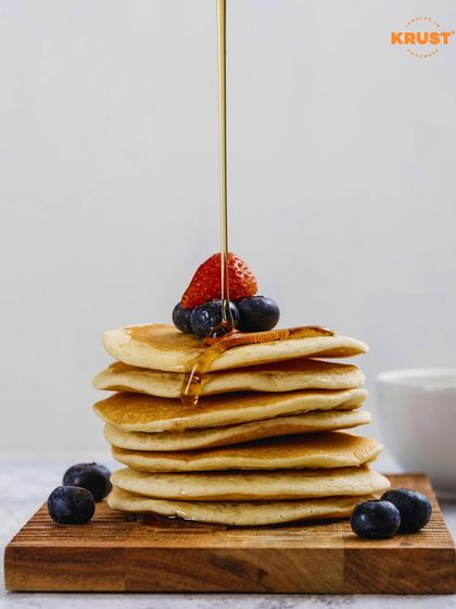 A tall stack of perfect pancakes topped with fresh berries and a drizzle of syrup. A simple, elegant, and delicious goal for our workshop participants.