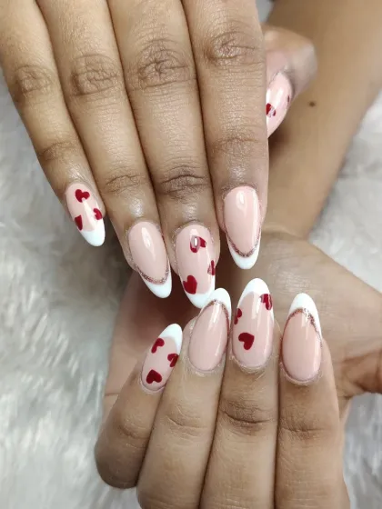 A close-up of this lovely heart-themed nail art. The design includes a modern French tip with a thin silver glitter line for extra definition.