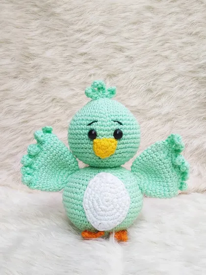 A full front view of the Koda bird amigurumi against a soft white background. His simple and sweet design makes him so lovable.