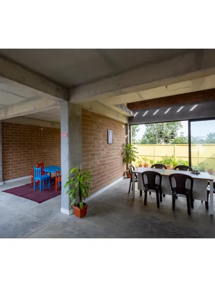 A multi-purpose room at the Mathru Centre, with large windows that open to a green space. This flexible area can be used for dining, learning, or therapy, always maintaining a strong connection to the outdoors.