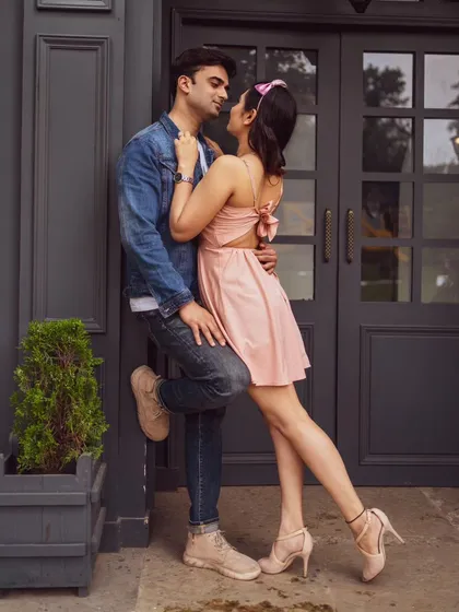 A stylish couple poses against a modern grey door, creating a chic, urban vibe. Our location offers a mix of natural and architectural backdrops to suit any concept.