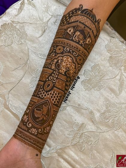 A side view of a completed bridal arm design, showing the beautiful combination of peacocks, elephants, and ceremonial motifs.