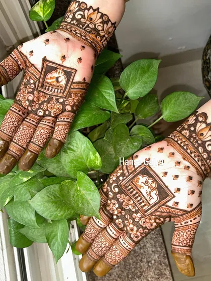 A lovely Karwachauth design with a small, framed portrait element. It's a great choice for someone who wants a touch of personalization in their festive mehendi.