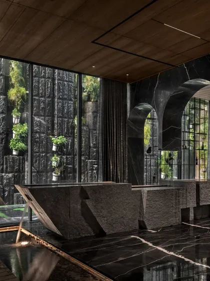 For the Green Court Villa, I designed this split stone bar counter to be the heart of the entertainment space. It's not just a functional element but a sculptural masterpiece that interacts with a tranquil water body, seamlessly merging the indoors with the calming presence of nature. This is how I create immersive guest experiences.