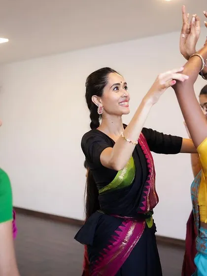 The Guru-Shishya tradition is the heart of my teaching. Here, I am guiding a student, refining her hand gestures and posture, ensuring personal attention and correct technique in our group classes.