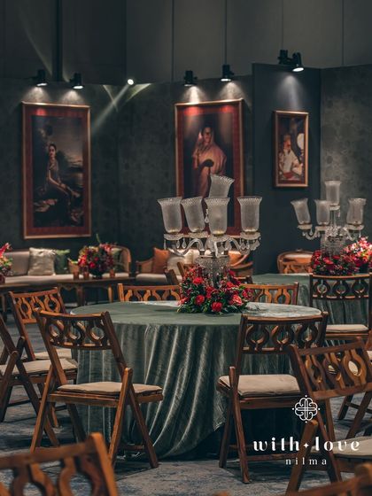 A full view of the guest seating area, showing the round tables with velvet cloths and candelabra centerpieces. The layout is designed for both elegance and social interaction.