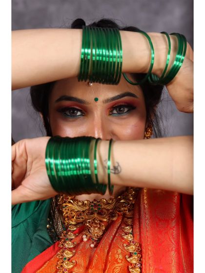 A creative and playful studio portrait, using green bangles to frame the eyes and add a pop of color.