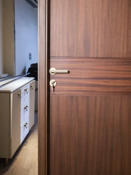 A beautiful fluted veneer door seen from an angle, showing how it adds texture and sophistication to a room. The simple hardware complements the design perfectly.