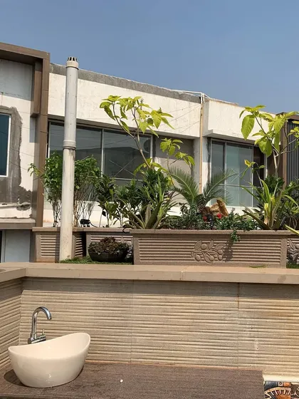 A view of a rooftop terrace project featuring large, built-in planters filled with a mix of ornamental and leafy green plants.